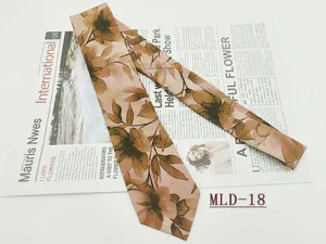 Primo piano della cravatta in cotone con stampa floreale vintage, trama fine e motivo marrone.