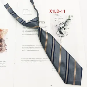 Dettaglio cravatta uniforme scolastica a righe grigie, jacquard poliestere con fascia elastica.