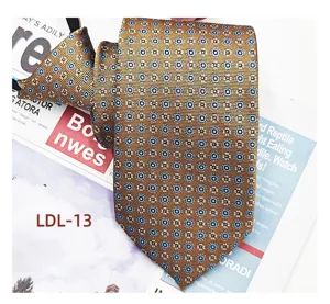 Golden jacquard zipper tie detail showing intricate geometric pattern texture and fine fabric.