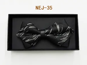 Detailed view of the elegant black bow tie with silver woven pattern inside a gift box.