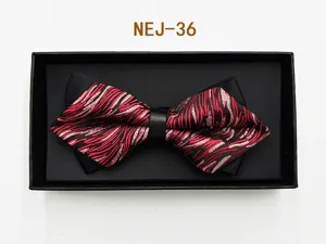 Detail view of a men red and black patterned bow tie neatly packed inside a black gift box.
