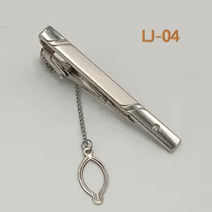 Silver metal tie clip detail, elegant business accessory with safety chain and sparkling crystal.