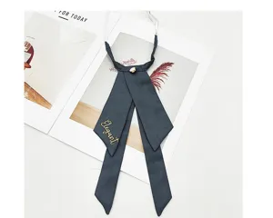 Detailed shot of dark grey JK bow tie featuring golden embroidery and elegant ribbon design.