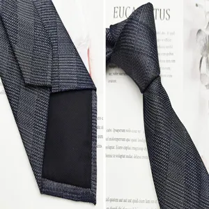 Dettaglio cravatta da uomo in seta con tessuto jacquard testurizzato e fodera posteriore pulita.