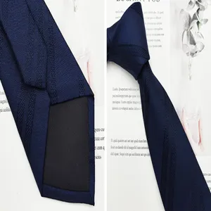 Vista dettagliata della cravatta in seta blu navy, motivo jacquard, elegante accessorio formale.