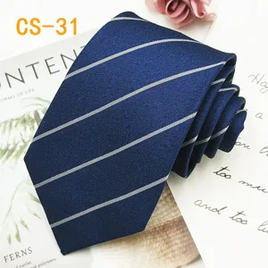 Vista dettagliata di una cravatta in seta a righe blu scuro con raffinata trama jacquard.