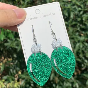 Nahaufnahme von gruenen glitzernden Gluehbirnen Acryl Ohrringen mit Silberhaken Weihnachten.