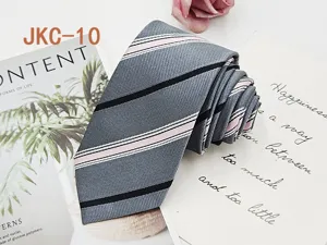 Detail shot of grey JK uniform tie featuring elegant pink and black diagonal stripes fabric.