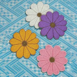 Primer plano detallado de posavasos de cuentas de girasol hechos a mano sobre tela.