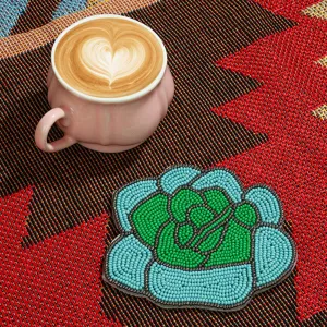 Close-up detail of the handmade beaded rose coaster with a coffee cup on the colorful woven mat.