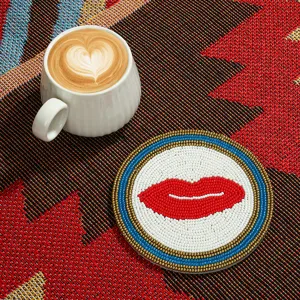 Sous-verre de perles artisanale avec un design de lèvres rouges pour la déco de table.
