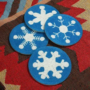 Vue detaillee de sous-verres faits main en perles bleues avec motifs de flocons de neige.