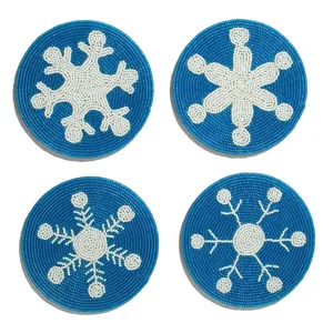 Détail en gros plan de sous-verres bleus perlés à la main avec de délicatifs motifs de flocons.
