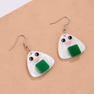 Vue de détail rapprochée de boucles d'oreilles en acrylique boule de riz onigiri souriantes.