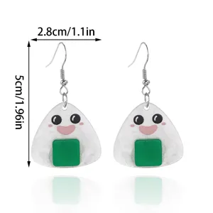 Gros plan détaillé des jolies boucles d'oreilles en acrylique onigiri avec détail vert.