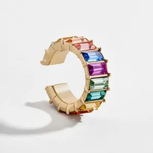 Detailaufnahme einer goldfarbenen Regenbogen Kristall Ohrklemme, bunte Baguette Zirkonia.