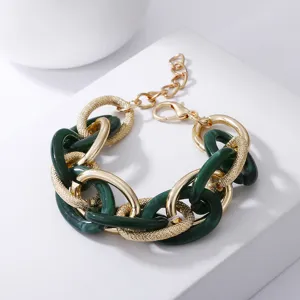 Detailaufnahme des retro chunky Kettenarmbands mit gruenem Acryl und goldenen Metallgliedern.
