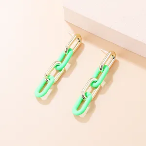Nahaufnahme der trendy grüne und goldene Kettenglieder Ohrringe mit Acryl und Metall Elementen.