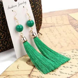 Grüne Quasten Ohrringe mit Perlenakzenten auf Präsentationskarte. Elegantes langes Design für Damen.