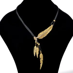 Detailaufnahme einer goldenen Feder-Halskette mit filigranen Strasssteinen an Kordel.