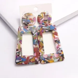 Detaillierte Nahaufnahme bunter geometrischer Acryl-Ohrringe mit modischem Schildpatt-Muster.