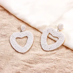 Handgefertigte weiße Perlen Herz Ohrringe Detailaufnahme, Boho Stil Schmuck für Damen.