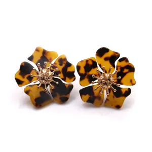 Detailaufnahme von Schildpatt Acetat Blumen Ohrringen mit goldenen Metall Staubblättern.