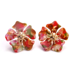 Nahaufnahme von bunten Vintage Blumen Acryl Ohrsteckern mit goldenen Staubgefäßen.