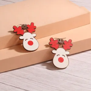 Niedliche hölzerne Weihnachtsrentier Ohrringe mit roten Geweihen, festlicher Feiertagsschmuck.