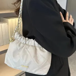 Vue détaillée du sac à bandoulière matelassé élégant avec de superbes ferrures dorées.