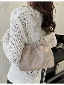 Vue détaillée du sac à bandoulière matelassé avec chaîne et élégante barre en métal.