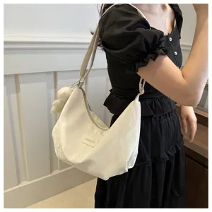 Bolso cruzado blanco con diseño hobo suave y dije de peluche para uso diario.