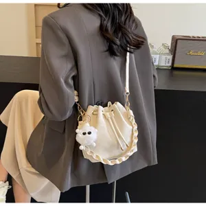 Vista de primer plano detallada de un elegante bolso de cubo blanco con correa trenzada.