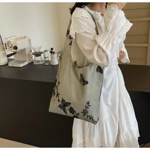 Nahaufnahme der bestickten Schmetterlings-Spitzenschultertasche mit feinen Details und Design.