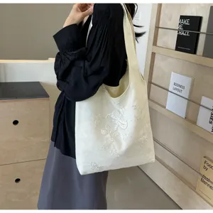 Weißer Leinen-Shopper mit filigraner Blumen- und Schmetterlingsstickerei im Stil.