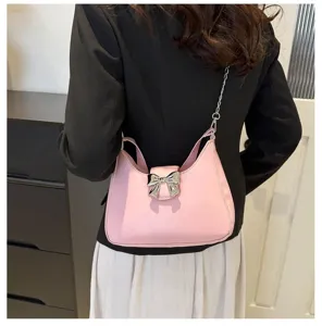 Vista dettagliata della elegante borsa a tracolla rosa con fiocco argentato e catena.