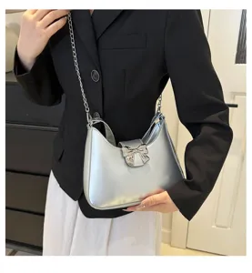 Moderna borsa a spalla argentata metallica con elegante fiocco in metallo e catena.