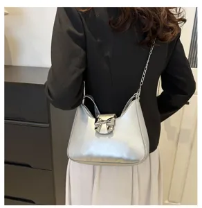 Vista dettagliata della borsa a spalla metallica argentata con fiocco elegante e catena.