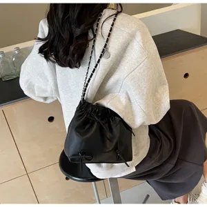 Zwarte schoudertas met trekkoord voor dames, stijlvolle ketting crossbody tas met strikdetail.