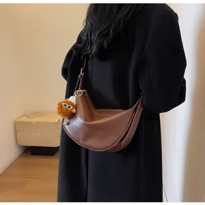 Detailansicht der braunen PU Leder Hobo Umhängetasche mit niedlichem Plüschtier Anhänger.