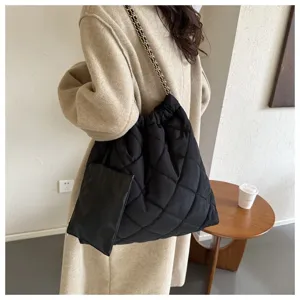 Detailansicht der schwarzen gesteppten Kettentasche, modische Puffer-Tasche für Damen.