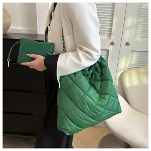Detailaufnahme der grünen gesteppten Schultertasche mit Kette und kleiner Tasche.