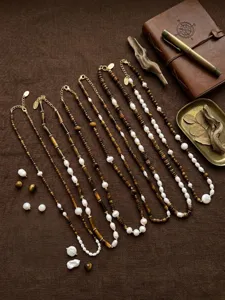 Detailed view of vintage pearl and beaded layered necklaces with copper 18k gold plating.