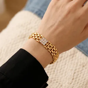 Vista dettagliata del bracciale a maglie piatte dorate a più fili con cristallo quadrato.