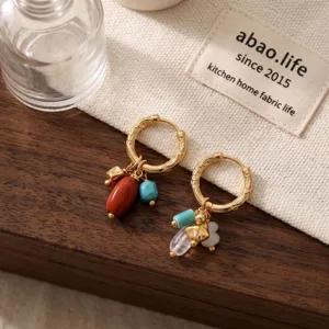 Detailed shot of bohemian style natural stone crystal and turquoise dangling earrings in gold.