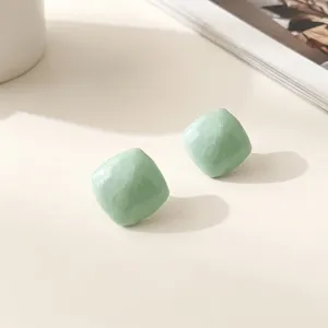 Mint green geometric resin stud earrings detail close up view, minimalist aesthetic.
