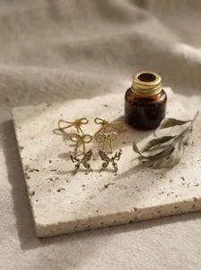 Ensemble de boucles d'oreilles nœud et papillon dorées rétro, design élégant pour femmes.