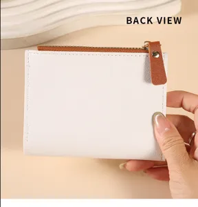 Detailed view of white minimalist short wallet showing back design with brown zipper pull.