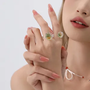 Close-up detail of a handmade fused glass double-finger ring with vibrant green accents.