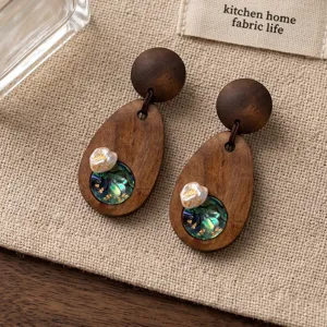 Orecchini in legno fatti a mano con perla naturale e madreperla, scatto di dettaglio vintage.